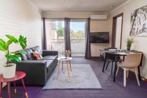 a living room with a couch and a table at Apartment 9 Burswood in Perth