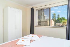 a bedroom with a bed and a large window at Apartment 9 Burswood in Perth
