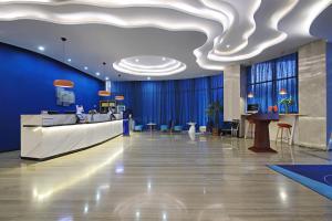a lobby with blue walls and a white ceiling at Holiday Inn Express Linyi West by IHG in Linyi