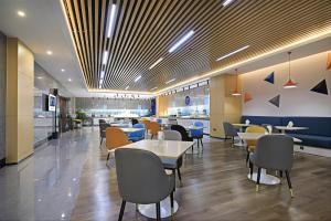 a restaurant with tables and chairs in a cafeteria at Holiday Inn Express Linyi West by IHG in Linyi