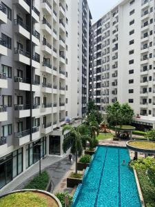 an apartment complex with a swimming pool and two tall buildings at PARANAQUE STAYCATION at SPRING RESIDENCES T3 U1231 in Manila