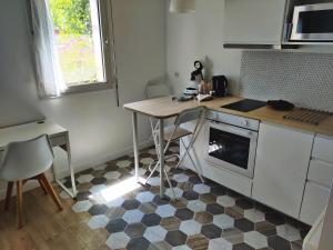 a kitchen with a counter and a table and a stove at Calme, tranquille, proche Paris in Bagneux