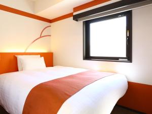 a bedroom with a bed and a window at Hotel Wing International Select Ueno Okachimachi in Tokyo