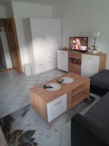 a living room with a coffee table and a tv at Studio apartman City Centre Rogatica in Rogatica +2 photos