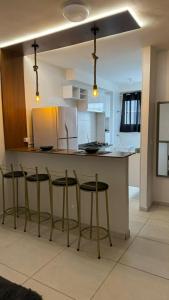 una cucina con quattro sgabelli da bar e un bancone di Studio Capital do Forró a Caruaru