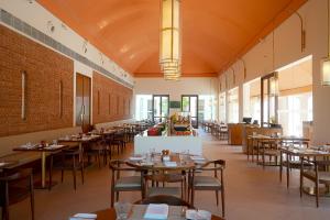 a dining room with tables and chairs at Marasa Sarovar Premiere, Bodhgaya in Bodh Gaya