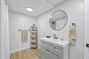 a white bathroom with a sink and a mirror at Riverfront Cottages in Wasaga Beach +31 photos