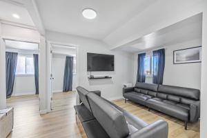 a living room with black leather furniture and a flat screen tv at Riverfront Cottages in Wasaga Beach