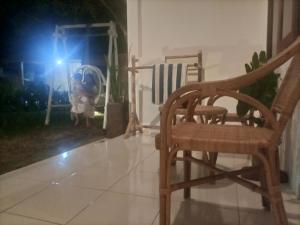 a wooden chair sitting on a tiled floor with a light at Efrata Villa in Gili Islands +2 photos