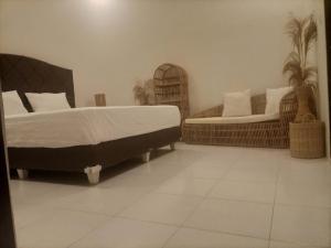 a bedroom with two beds and two wicker chairs at Efrata Villa in Gili Islands