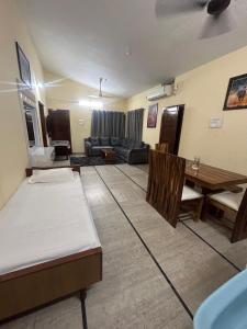 a living room with two beds and a table at Udupi Coral Homestay in Kalyānpur