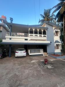 a white car parked in front of a house at Udupi Coral Homestay in Kalyānpur
