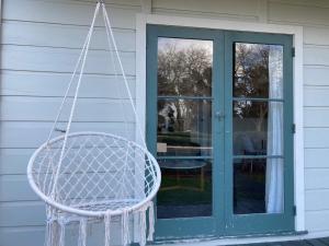 a swinging chair in front of a door at Riverside Villa in Whanganui