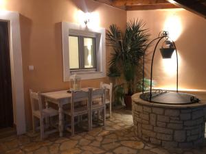 a dining room with a table and a fire place at Casa Ortensia in Kato Korakiana