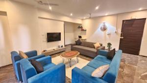 a living room with blue couches and a tv at Lite Stays - Vile Parle East in Mumbai