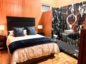 Terebinte Bed & Breakfast في ديربان: غرفة نوم بسرير وحمام مع حوض