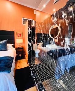 uma casa de banho com 2 camas, um lavatório e um espelho. em Terebinte Bed & Breakfast em Durban