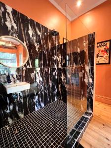 uma casa de banho com um chuveiro, um lavatório e um espelho. em Terebinte Bed & Breakfast em Durban