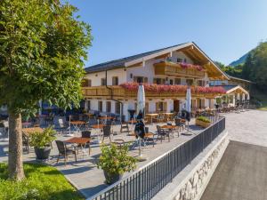 ein Hotel mit Stühlen und Tischen und einem Gebäude in der Unterkunft Hotel Hanauerlehen - ruhige & zentrale Top-Lage - mit Schwimmbad, Sauna, Parkplätze & Café - bayerischer Familienbetrieb in Schönau am Königssee