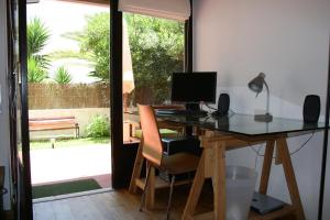 a home office with a desk with a computer on it at At the beach with a private garden in Carcavelos