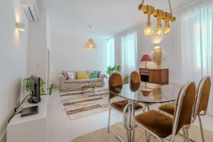 a living room with a glass table and chairs at Sunny & Charming Oeiras Historical Center House in Oeiras