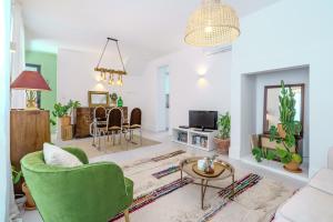 a living room with a green chair and a table at Sunny & Charming Oeiras Historical Center House in Oeiras