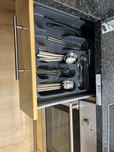 a drawer filled with utensils in a cabinet at Kettering Service Accomodation 2BRH FreeParking Wifi Smart TV Tea & coffee in Kettering
