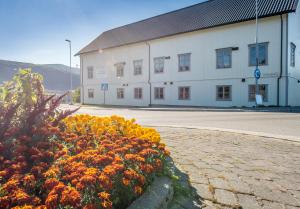 a large white building with flowers in front of it at Toranes Overnatting in Mo i Rana