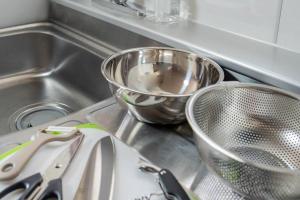 a kitchen sink with two strainer bowls and a strainer at Guesthouse CoBo in Otaru