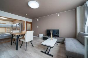a living room with a table and a couch at Guesthouse CoBo in Otaru