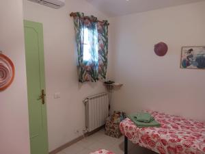 a room with a bed and a window and a table at La casina delle bimbe in Santa Luce