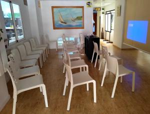 a waiting room with white chairs and a screen at Hotel Alaska in San Pedro del Pinatar