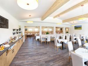 ein Esszimmer mit Tischen und Stühlen und einer Tafel in der Unterkunft Hotel Hanauerlehen - ruhige & zentrale Top-Lage - mit Schwimmbad, Sauna, Parkplätze & Café - bayerischer Familienbetrieb in Schönau am Königssee
