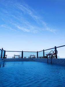 a swimming pool with benches in the water at Volga Hotel in Vung Tau