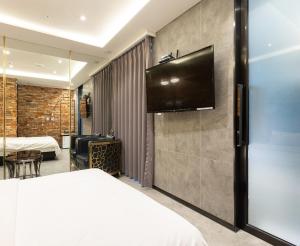 a hotel room with a bed and a flat screen tv at Desarts Hotel in Seoul