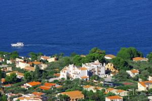 a small town with a boat in the water at Hotel Baia Del Capitano in Cefalù