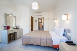 a bedroom with a bed and a desk and a sink at Erato Hotel in Agia Marina Aegina