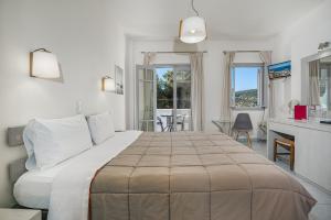 a bedroom with a large bed and a living room at Erato Hotel in Agia Marina Aegina