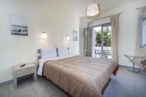 a bedroom with a large bed and a balcony at Erato Hotel in Agia Marina Aegina +37 photos