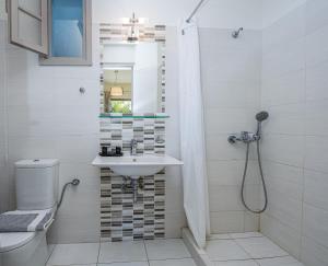 a bathroom with a sink and a toilet and a mirror at Erato Hotel in Agia Marina Aegina