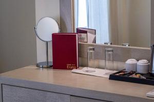 a counter with a mirror and a book and glasses at Erato Hotel in Agia Marina Aegina
