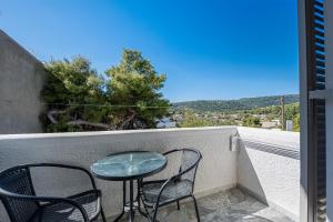 a table and chairs on a balcony with a view at Erato Hotel in Agia Marina Aegina
