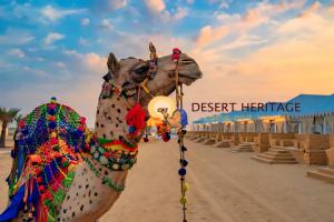 un chameau décoré sur un chemin de terre en face d'une résidence dans le désert dans l'établissement Desert Heritage Luxury Camp And Resort, à Jaisalmer
