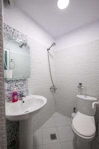Un baño blanco con inodoro y lavabo. en Guesthouse Siars, en Ksamil 32 fotos más