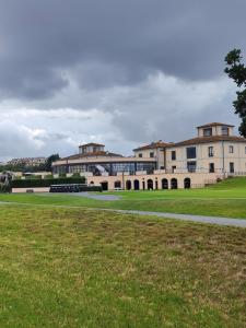 a large building with a grass field in front of it at Agape in Marco Simone