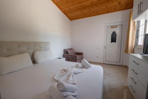 Un dormitorio con una cama blanca con toallas. en Guesthouse Siars, en Ksamil