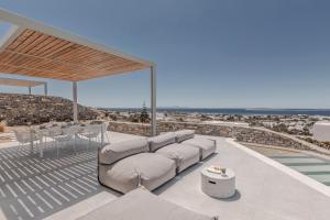 a living room with a couch and a view of the ocean at Melora Villas Paros in Aliki