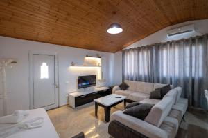 Una sala de estar con un sofá y un televisor. en Guesthouse Siars, en Ksamil