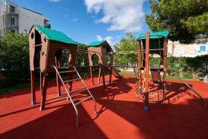 a playground with a slide on a red ground at AluaSun Continental Park Hotel & Apartments in Playa de Muro +33 photos