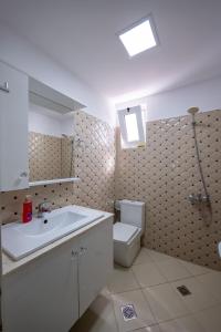 Un baño con lavabo blanco y inodoro. en Guesthouse Siars, en Ksamil